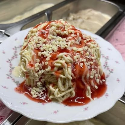 Spaghettieis mit Erdbeersoße und weißen Schokoraspeln